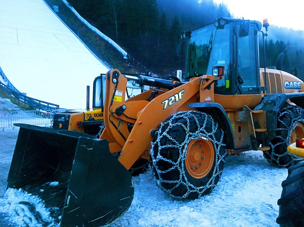Case 721F wheel loader, equipped with snow chains, at work at the ski flying championships in Austria.