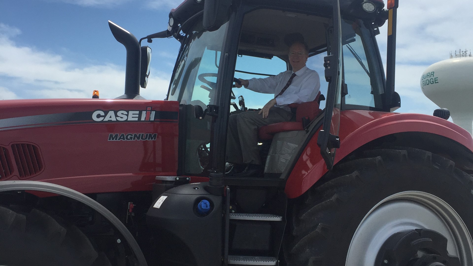Congressman Bill Foster poses in a Case Ih Magnum tractor during visit to CNH Industrial Burr Ridge