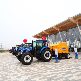 New Holland tractors and balers in front of the new industrial complex in Harbin