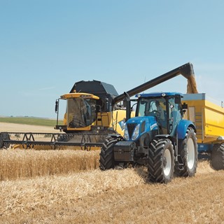 New Holland CX6090 Elevation Combine Harvester in the Field conducting on the go unloading