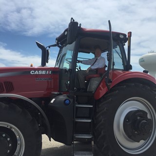 Congressman Bill Foster poses in a Case Ih Magnum tractor during visit to CNH Industrial Burr Ridge