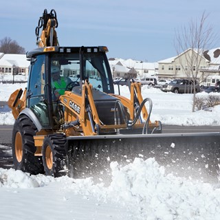 CASE 590 SN Backhoe Loader conducting snow removal