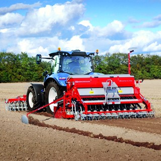 A New Holland Tractor working with a Seed Drill