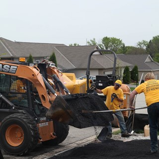 Crews work on a driveway project with a Skid Steer Loader