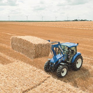 The T5 tractor range stacking bales in the field