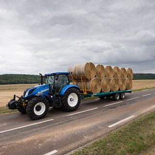 New Holland T6.175 Dynamic Command conducting road transport with a bale trailer