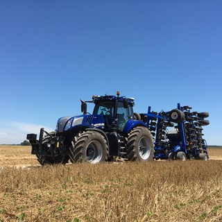 New Holland T8 NHDrive Autonomous Concept Tractor on the road with the 2085 Air Disc Drill in transport position