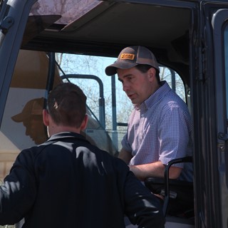 Andrew Dargatz of CASE discusses the finer points of excavator operation with Governor Walker