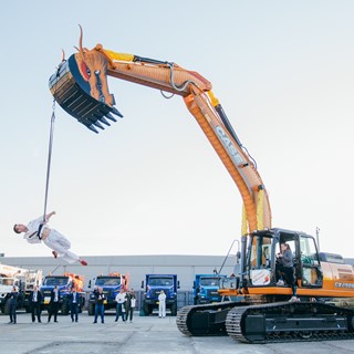 An aerial gymnast dressed in kimono with a dragon excavator