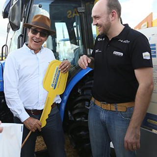 Produtor Gabriel Afonso Mei de Oliveira, da Fazenda Bom Jesus, segura chave simbólica do trator entregue pelo vice-pres