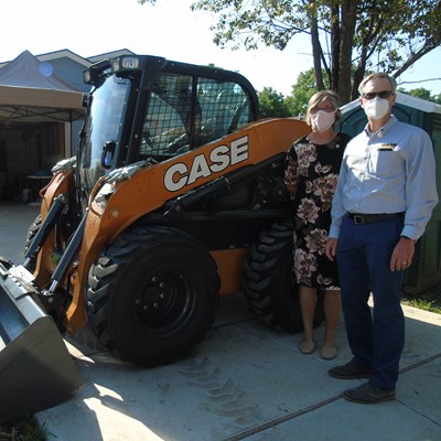 Ann Fox with Habitat and Troy Williams with CASE and the donated skid steer
