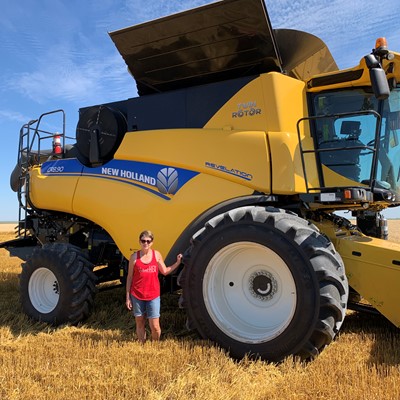 Tracy Zeorian, fundadora da HarvestHER, posa com sua colheitadeira CR8.90