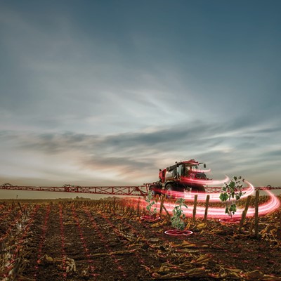 A modern agricultural sprayer is operating in a field at dusk, with a dramatic sky in the background. The sprayer is surrounded by swirling red light effects, emphasizing its motion as it applies treatment to the crops. The field is lined with rows of plants, showcasing a blend of technology and farming practices.