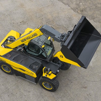 A yellow and black New Holland telescopic handler with a large front bucket attachment, viewed from above on a concrete surface.