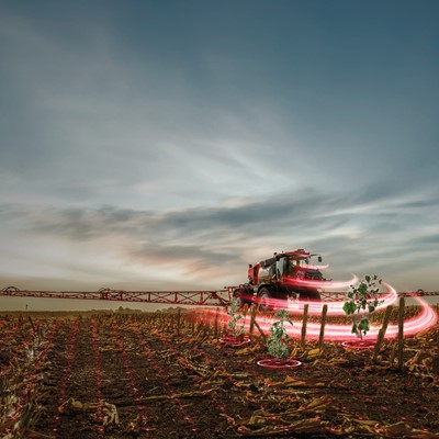 A red agricultural sprayer machine is operating in a harvested field at dusk, with digital light effects highlighting specific plants, symbolizing precision farming and advanced agricultural technology.