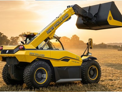 Yellow New Holland telescopic handler with a raised black and yellow bucket attachment in a harvested wheat field during sunset, showcasing agricultural machinery and hybrid power technology.