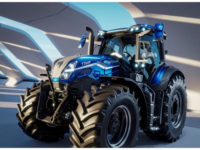 A modern blue New Holland T7.225 tractor with large rugged tires, sleek design, and multiple front and roof lights, parked indoors under a structure with curved beams casting shadows.