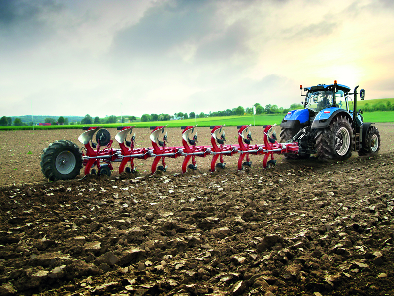 A New Holland tractor working with a plough A New Holland tractor working with a plough