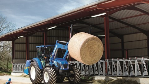 T4.95 with a front loader moving straw bales