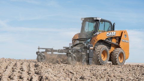 A Case Skid Steer Loader working on tilled soil