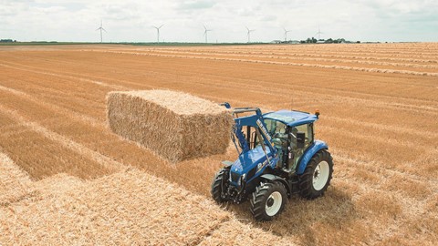 The T5 tractor range stacking bales in the field
