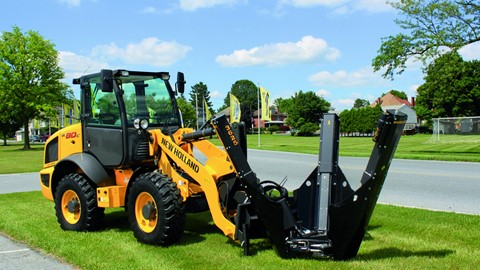 New Holland Construction with a tree removal implement attached