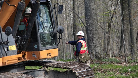 Team Rubicon Heavy Equipment Instructor Shane Pratt directs an excavator operator at a service project in Wisconsin