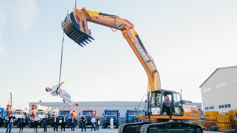 An aerial gymnast dressed in kimono with a dragon excavator