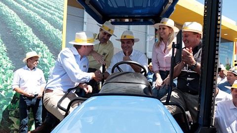 Diretor da New Holland cumprimenta governador do Paraná em cima de trator TL entregue a produtor rural. Foto: Eron Zeni.