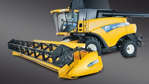 A New Holland combine harvester in bright yellow, featuring a large cab and a header attachment. The machine is designed for agricultural use, showcasing its modern design and functionality against a dark gray background.