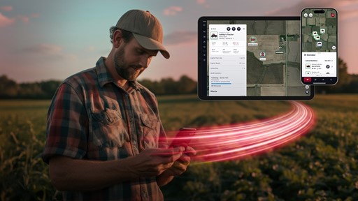 A farmer wearing a cap and plaid shirt stands in a field at sunset, looking at his smartphone. Digital overlays of a tablet and smartphone screen display a farm management app with maps and data about tractors and field activities, connected by red light trails symbolizing real-time data transfer.