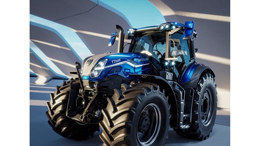 A modern blue New Holland T7.225 tractor with large rugged tires, sleek design, and multiple front and roof lights, parked indoors under a structure with curved beams casting shadows.