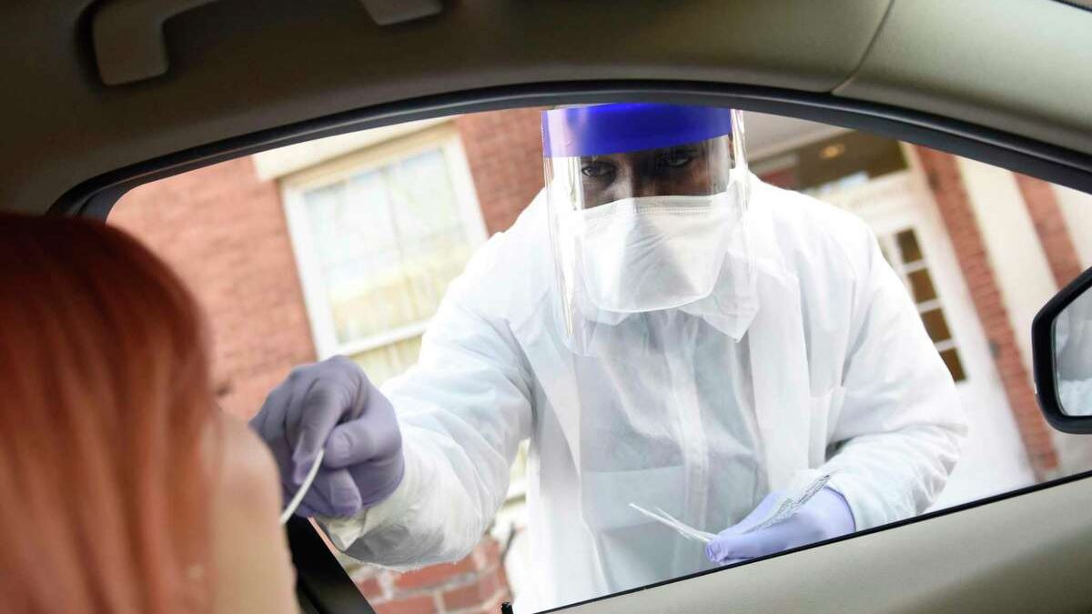 Phlebotomist Warren Dawkins demonstrates drive-thru testing for coronavirus at Murphy Medical Associates in Greenwich