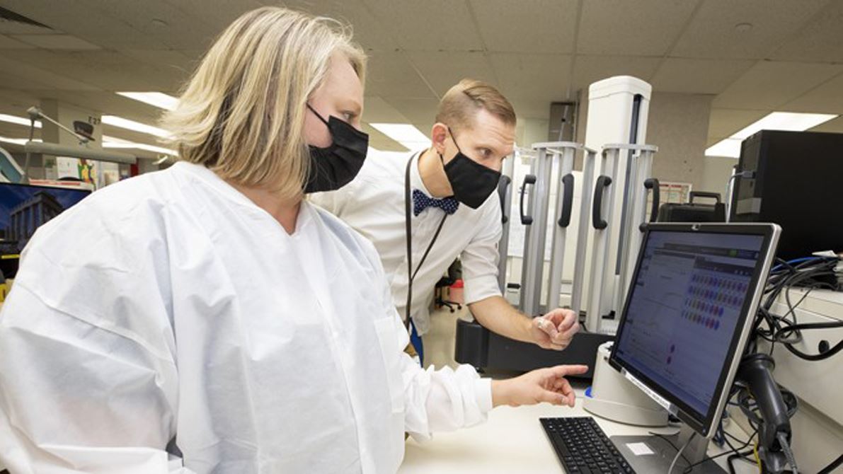 Alison Benton, SMB, and David Gaston, MD, PhD, discuss pcr data analysis as they prepare to begin in-house monkey pox te