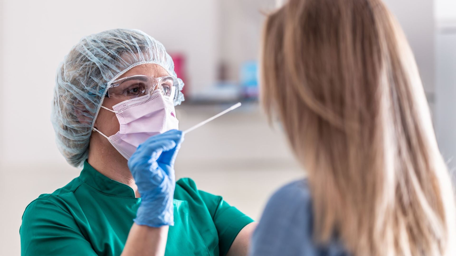 Well protected medical staff performs swab test