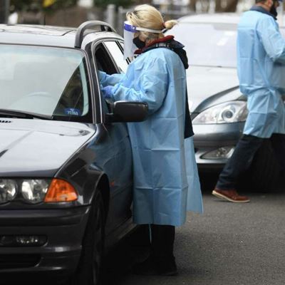 Laboratory technician Daphne Henri and office manager Javier Ortiz administer drive-thru COVID-19 tests outside