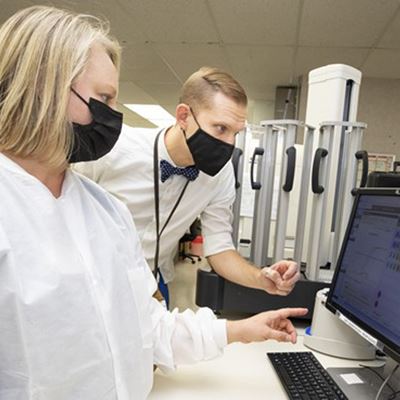 Alison Benton, SMB, and David Gaston, MD, PhD, discuss pcr data analysis as they prepare to begin in-house monkey pox te
