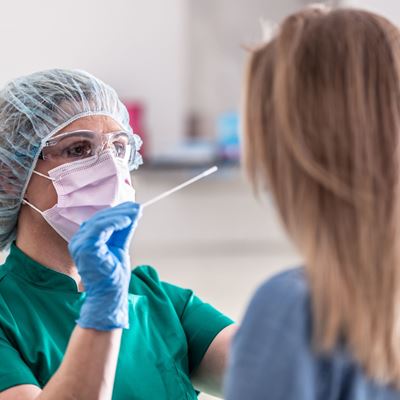 Well protected medical staff performs swab test