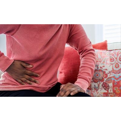 Close up of unrecognizable black woman sitting on couch with abdominal pain Photo Getty Images