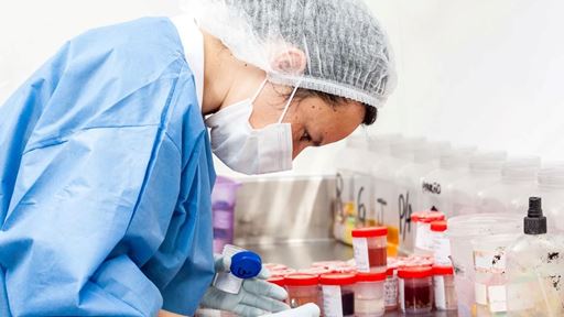 A scientist processes biopsy samples for examination