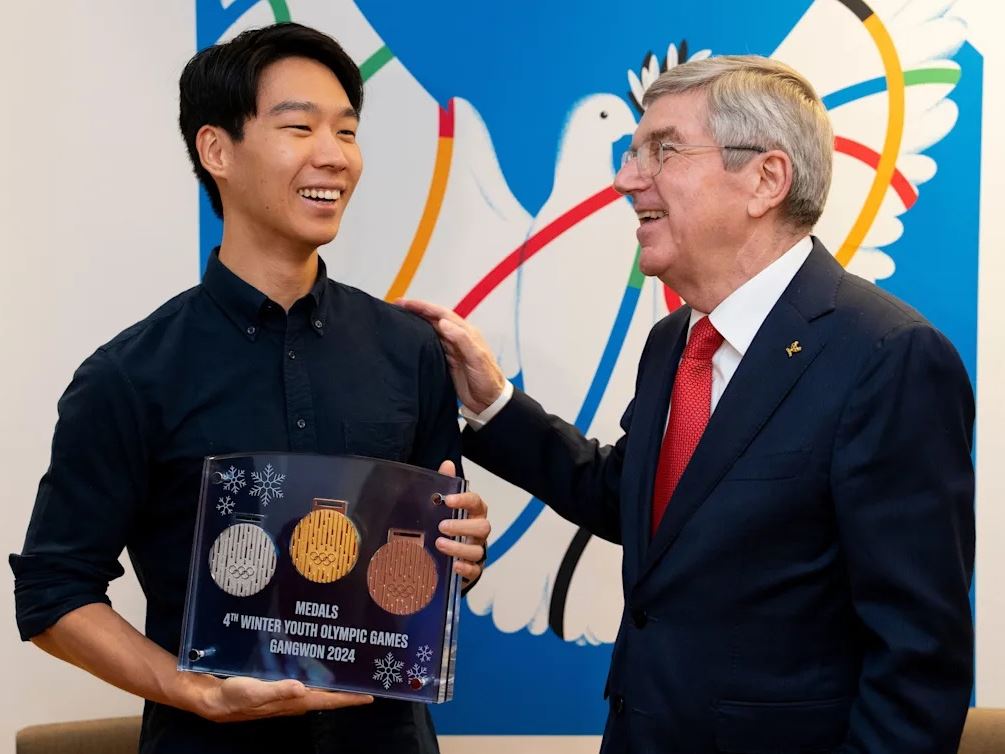 Winner of medal design competition presented with a set of his medals by IOC President Bach