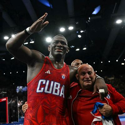 Cubas Mijain Lopez Nunez celebrates with his coach after beating Chiles Yasmani Acosta Fernandez in their mens greco rom