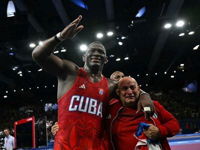 Cubas Mijain Lopez Nunez celebrates with his coach after beating Chiles Yasmani Acosta Fernandez in their mens greco rom