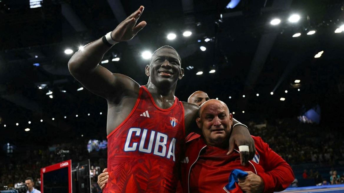 Cubas Mijain Lopez Nunez celebrates with his coach after beating Chiles Yasmani Acosta Fernandez in their mens greco rom