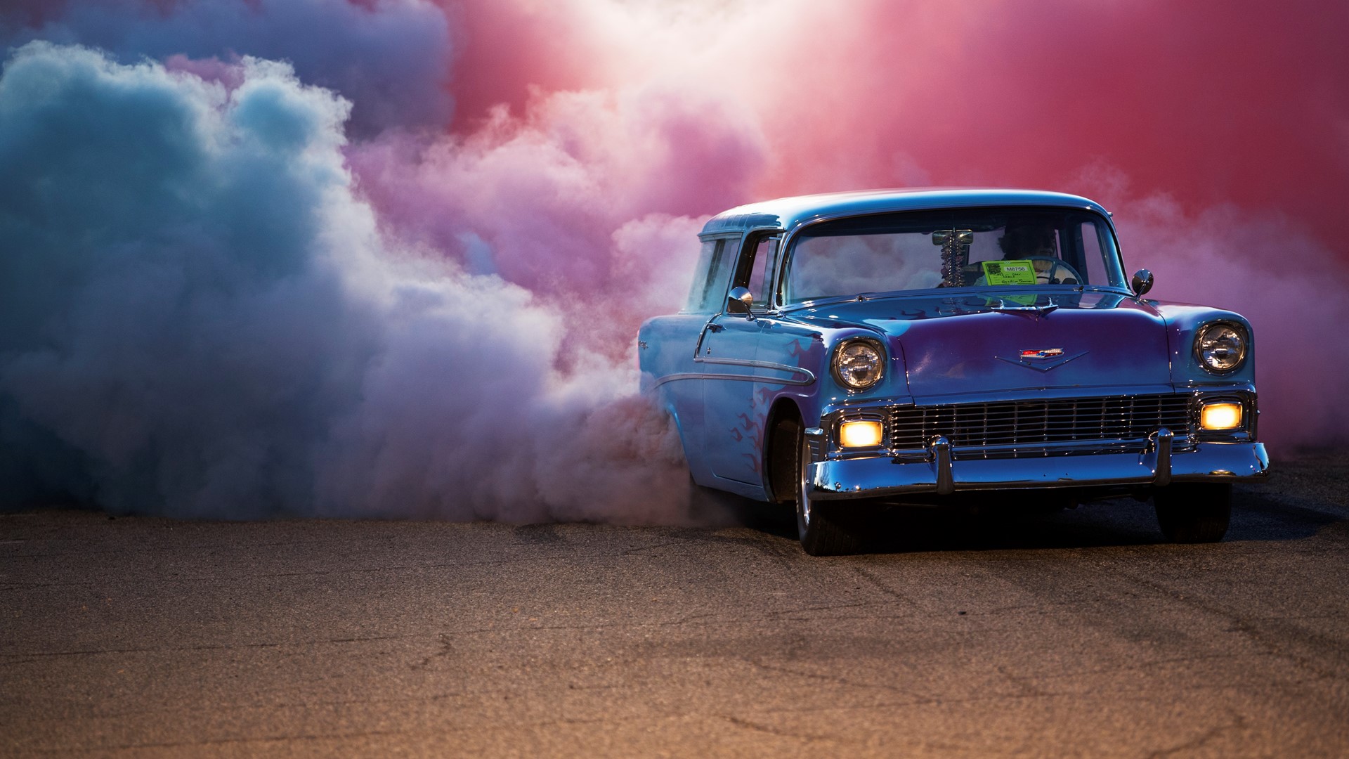 Reg Bennion sends up clouds of red and blue smoke from the tires of his 1956 Chevrolet Nomad