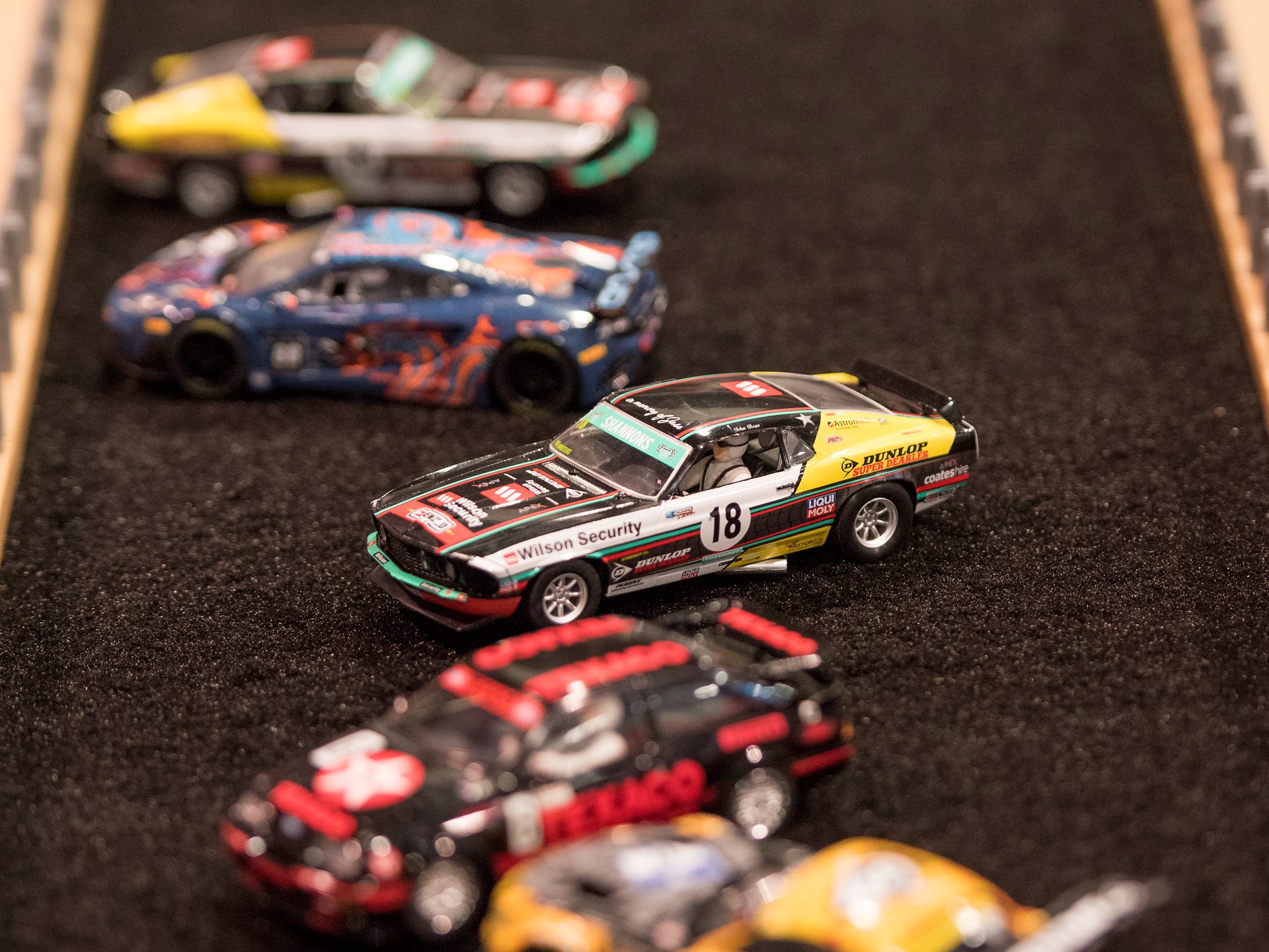 Slot cars are parked in the "infield" of a race track at the Specialty Equipment Market Association (SEMA) Show