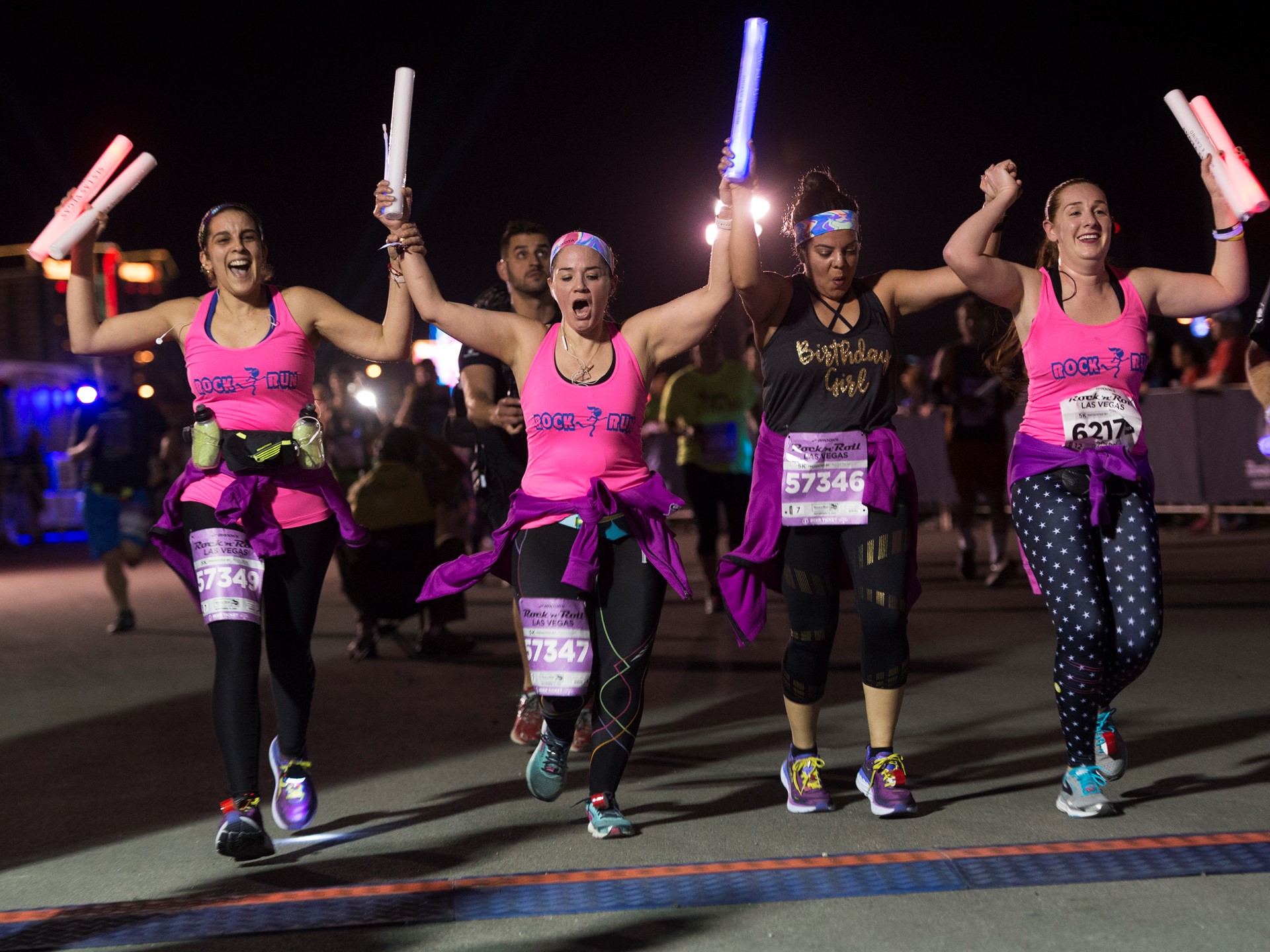 A group of women cross the finish line during the Rock 'n' Roll Las Vegas Marathon 5K run