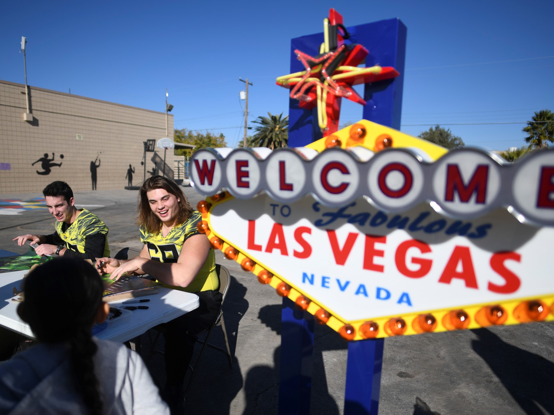 Oregon Ducks quarterback Taylor Alie and Oregon Ducks offensive lineman Shane Lemieux hand out autographed posters