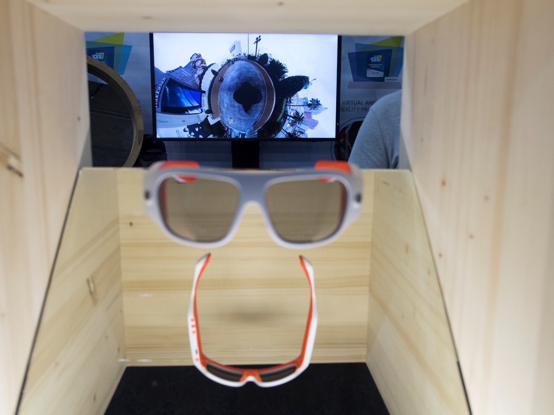 Glasses which film in 360 degrees, with footage displayed in the background, are seen during the first day of CES