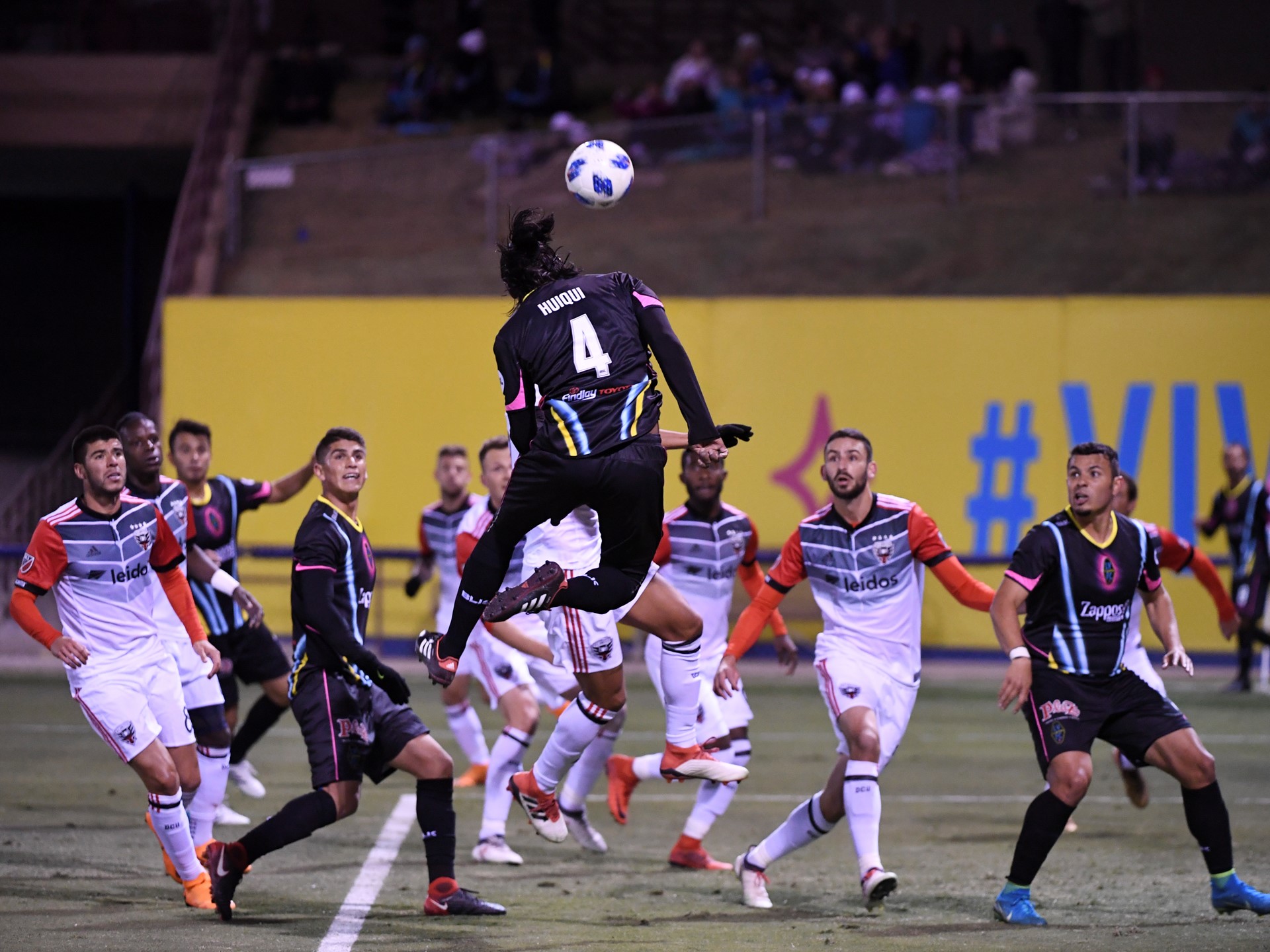 Players watch as Las Vegas Lights Joel Huiqui heads the ball towards the goal